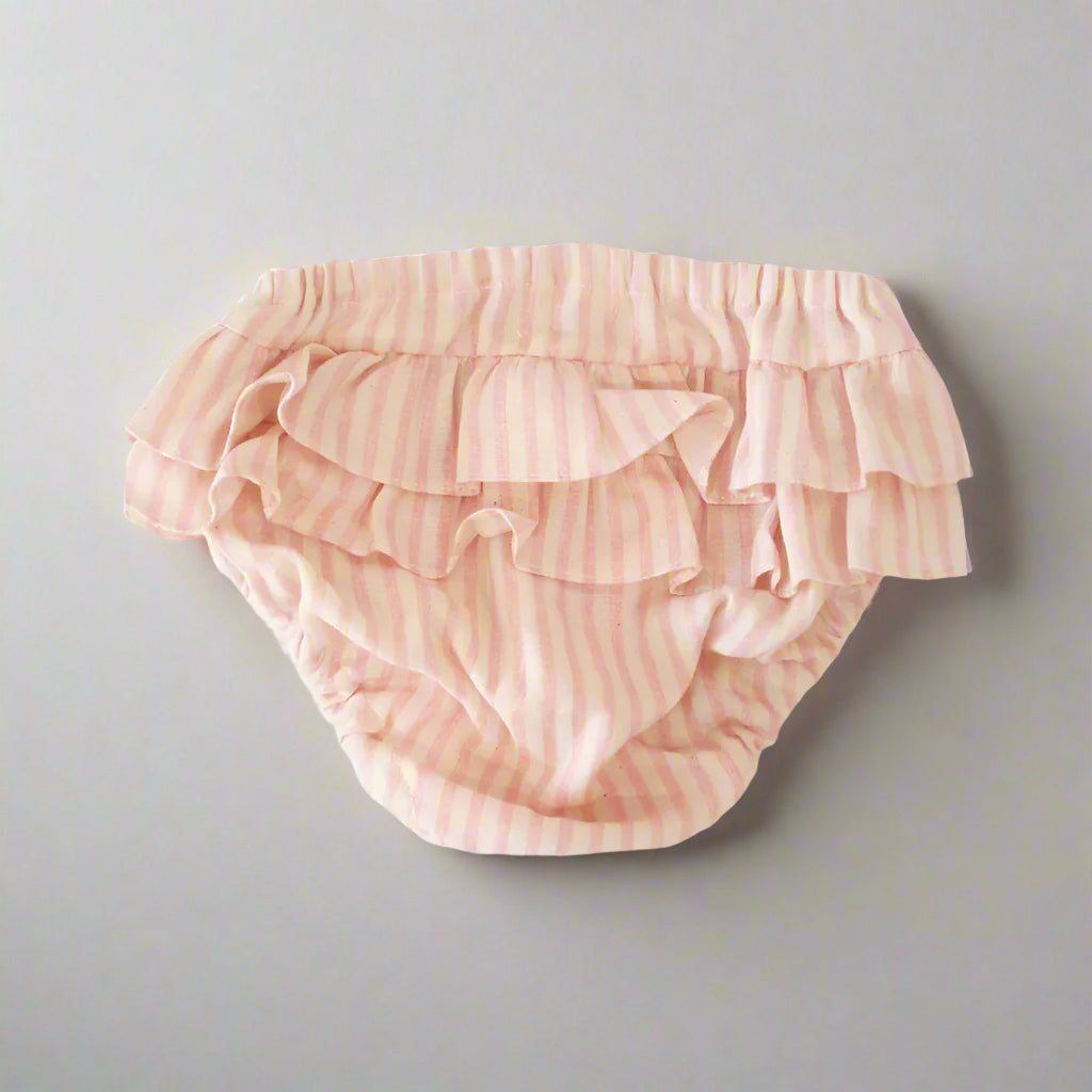 Pink ruffled baby bloomers on a white background